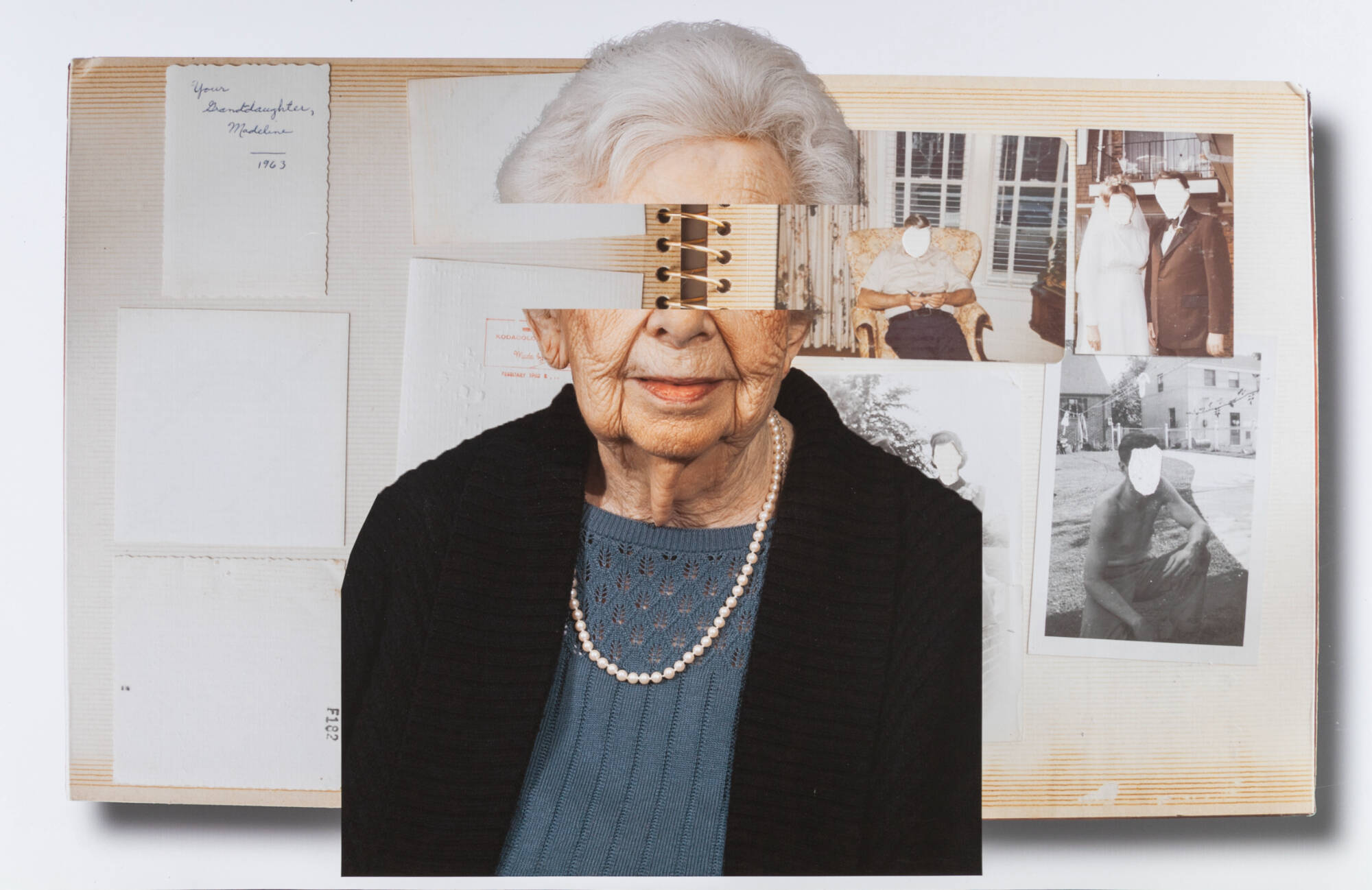 A picture of an older woman with her eyes cut out up against a scrapbook but all of the people have their faces cut out.